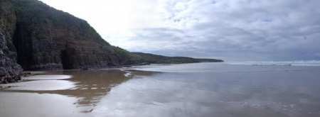 Cathedral Caves, and the tide racing in across the flat sands towards us